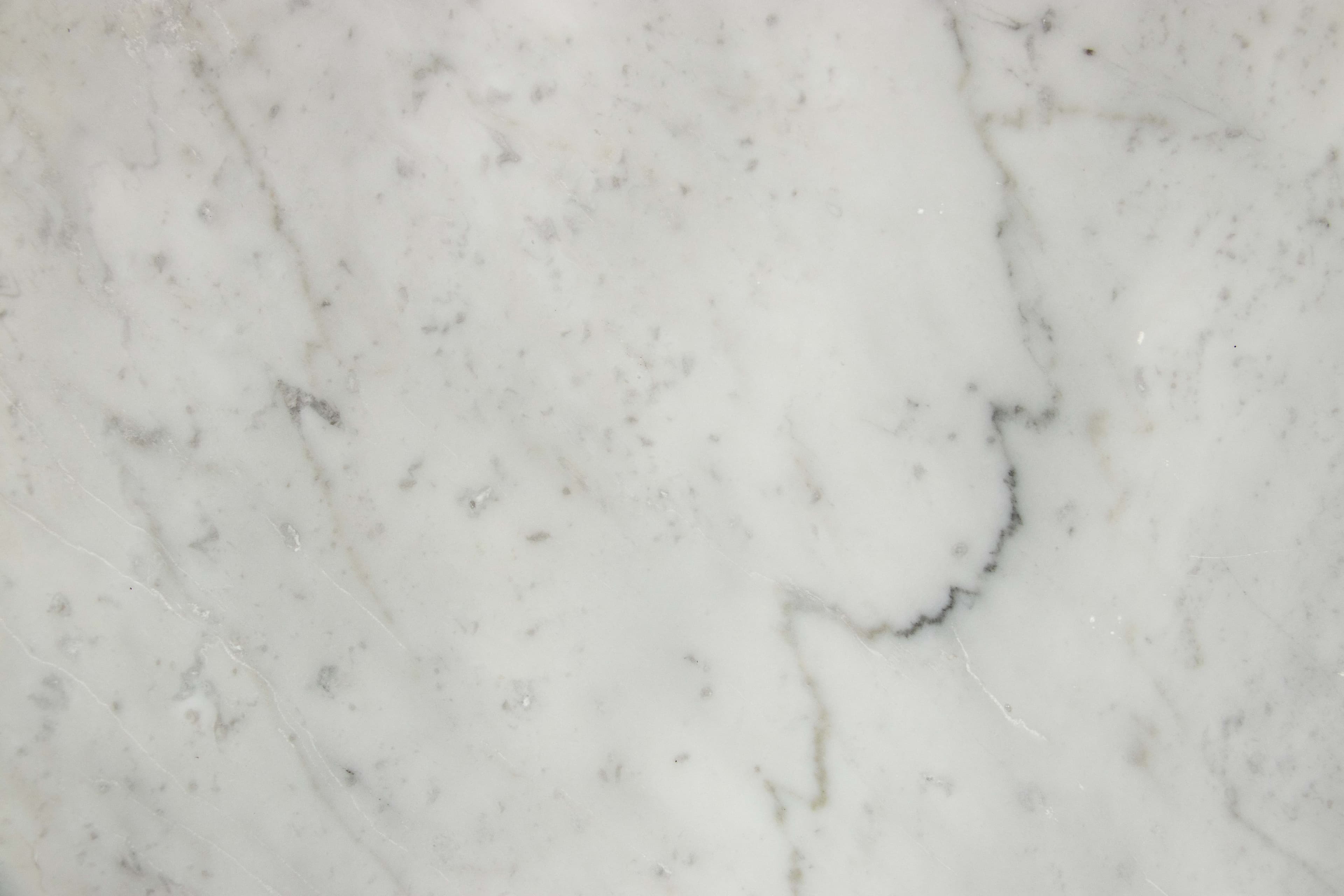 Close view of white Carrara marble with fine grey veining
